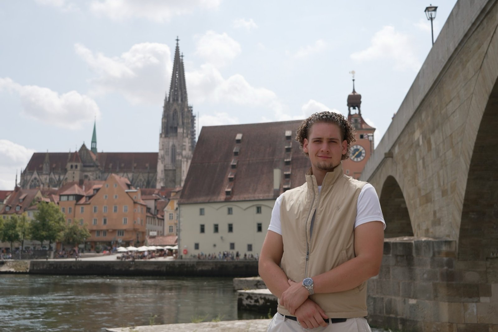 Dominik Waller, Immobilienmakler aus Regensburg, an der Steinernen Brücke — im Hintergrund der Dom St. Peter und die Regensburger Altstadt